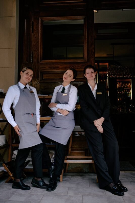 restaurant staff posing in uniforms outdoors